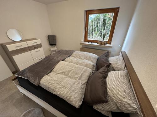 a bedroom with a bed and a window at GRETE - Haus Sonnenblick in Heringhausen