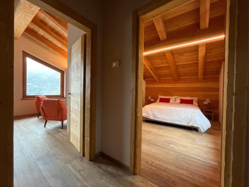 a bedroom with a bed and a large window at Baita La Pesse - Ad un passo dalle stelle in Nus