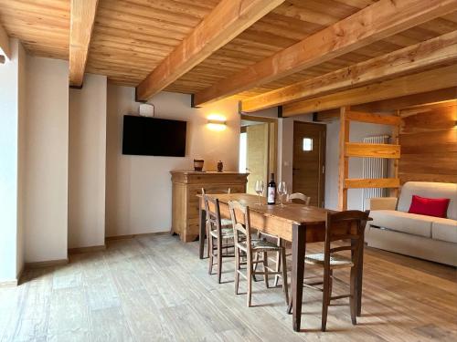 a dining room with a wooden table and chairs at Baita La Pesse - Ad un passo dalle stelle in Nus