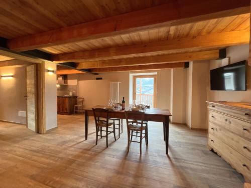 a kitchen and dining room with a wooden table and chairs at Baita La Pesse - Ad un passo dalle stelle in Nus