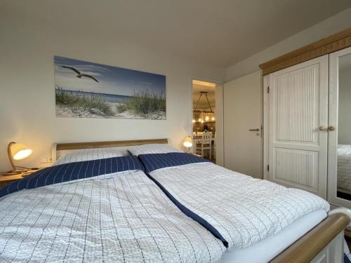 a large bed in a bedroom with a painting on the wall at Hansehaus 12 - MEERZEIT in Grömitz