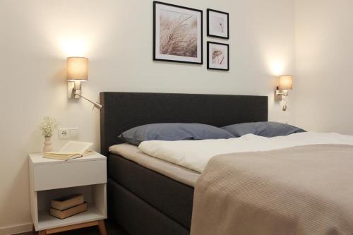 a bedroom with a bed and a table with a night stand at Sonnenweg 44-3 - HYGGE in Heringhausen