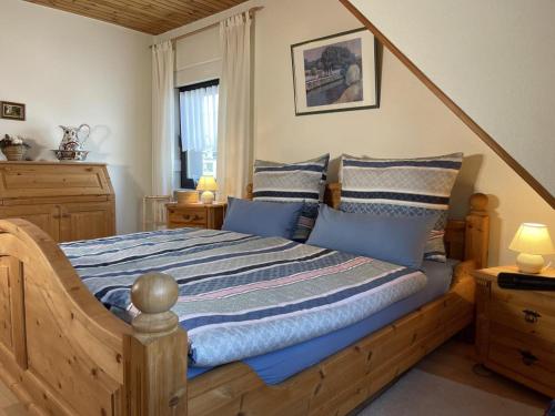 a bedroom with a wooden bed with blue pillows at BERGPARADIES Diemelsee in Schweinsbühl