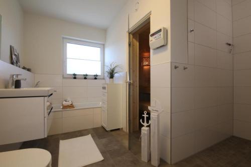 ein Badezimmer mit einem WC, einem Waschbecken und einer Badewanne in der Unterkunft Diemelblick 15 in Heringhausen