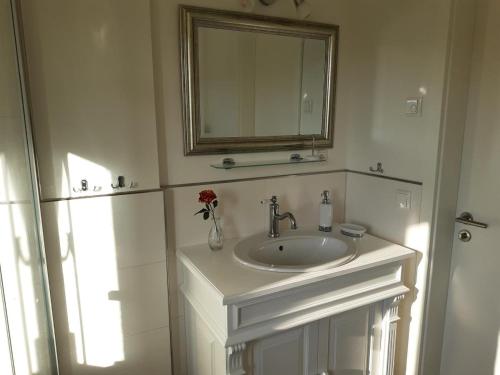 uma casa de banho branca com um lavatório e um espelho em Lütten Uttied em Gollwitz