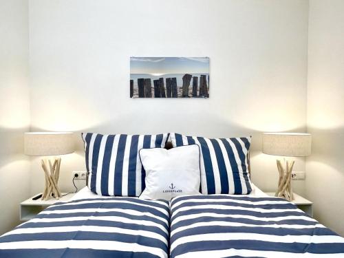 a bedroom with a bed with blue and white stripes at Kellenhusen Tor 8 in Kellenhusen