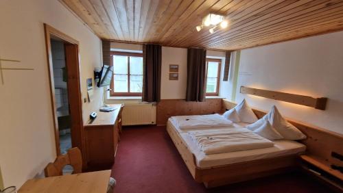 een slaapkamer met een bed en een bureau in een kamer bij Landgasthaus Jägerhof in Absberg