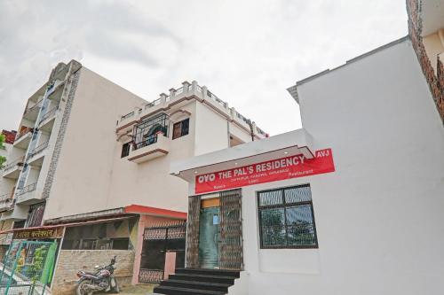 um edifício branco com um sinal vermelho em OYO The Pal's Residency em Kakarmatha