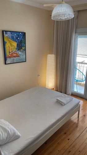ein weißes Bett in einem Zimmer mit Fenster in der Unterkunft Friendly guest house in Thessaloniki