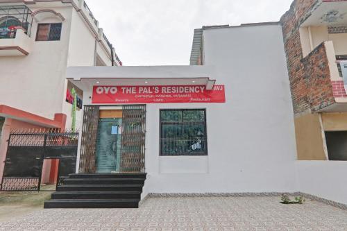 um edifício com um sinal vermelho na frente dele em OYO The Pal's Residency em Kakarmatha