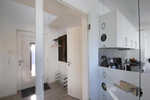 een keuken met witte kasten en een glazen deur bij Sonnenweg 24 in Heringhausen