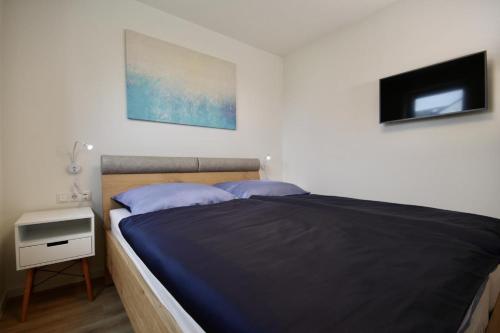 - une chambre avec un lit avec deux oreillers et une table de nuit dans l'établissement Kellenhusen Tor 11, à Kellenhusen