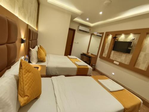 a hotel room with two beds and a television at Hotel Riva International Goregaon- Near NESCO in Mumbai