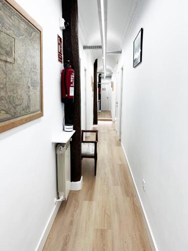 a hallway with white walls and a wooden floor at Pensión Régil in Donostia-San Sebastián