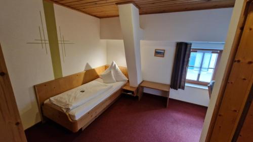 a bedroom with a bed with a wooden headboard and a window at Landgasthaus Jägerhof in Absberg