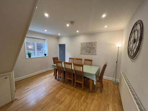 a dining room with a table and chairs at Great 4 bedroom House - Great Location - Garden - Parking - Fast WiFi - Smart TV - Newly decorated - sleeps up to 8! Only 10 mins drive to Sandbanks Beach! Close to Poole & Bournemouth in Parkstone