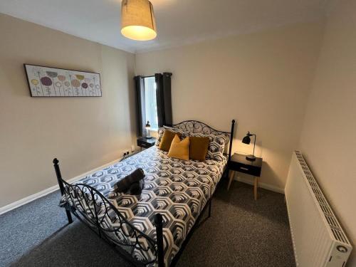 a bedroom with a bed with pillows on it at Great 4 bedroom House - Great Location - Garden - Parking - Fast WiFi - Smart TV - Newly decorated - sleeps up to 8! Only 10 mins drive to Sandbanks Beach! Close to Poole & Bournemouth in Parkstone