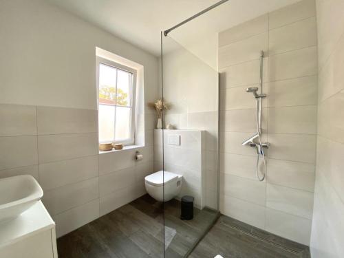 a bathroom with a toilet and a glass shower at Meerglück CUX in Cuxhaven