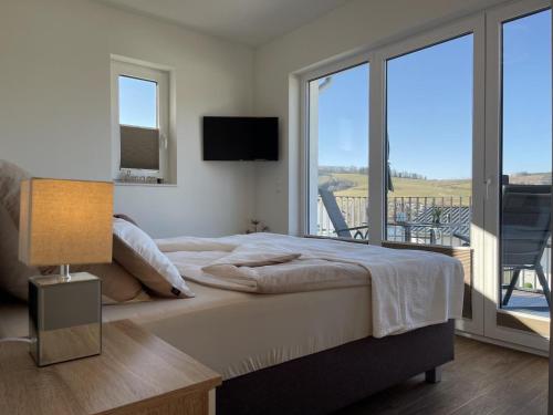 1 dormitorio con 1 cama grande y balcón en Diemelblick 18 en Heringhausen
