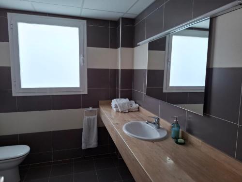 a bathroom with a sink and a toilet and a mirror at 3 Bed Chalet-Pool-Pets-Hot Tub-Parking-Garden in Chiva