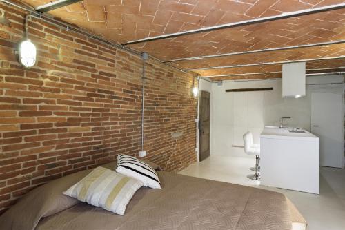 a brick wall in a bedroom with a bed at Loft n°18 in Arezzo
