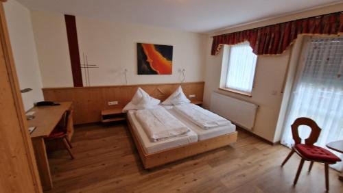 a bedroom with a bed and a desk and a table at Landgasthaus Jägerhof in Absberg