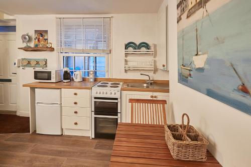 a kitchen with a sink and a stove at Seashell Cottage in Whitby