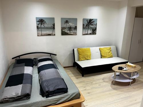 een woonkamer met een bed en een bank bij Apartmán u nádraží in Bílina