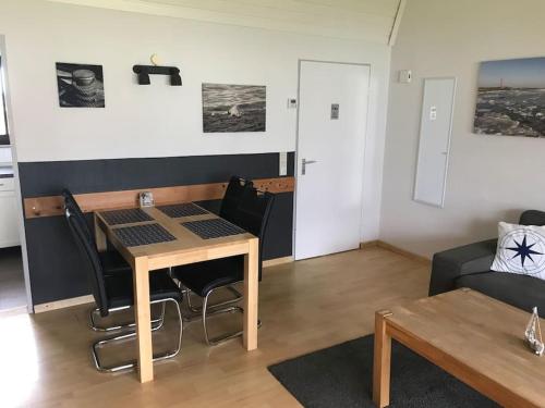 a living room with a table and a couch at Gemütlicher Bungalow in Butjadingen in Butjadingen
