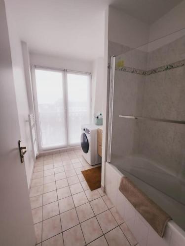 een badkamer met een douche en een tegelvloer bij Apartamento en Disneyland Paris in Chessy
