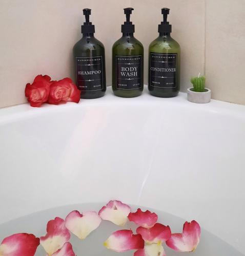 three bottles of wine on a shelf with flowers at Gardenia - Morfi Village with pool in Exopoli
