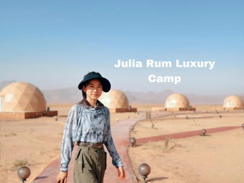 Una mujer con un sombrero parada en el desierto en Julia Rum Luxury Camp, en Wadi Rum