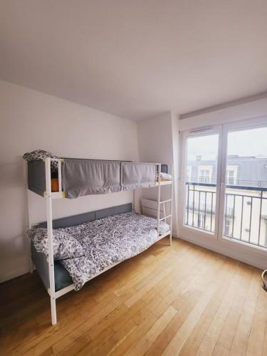 een slaapkamer met een stapelbed en een groot raam bij Apartamento en Disneyland Paris in Chessy
