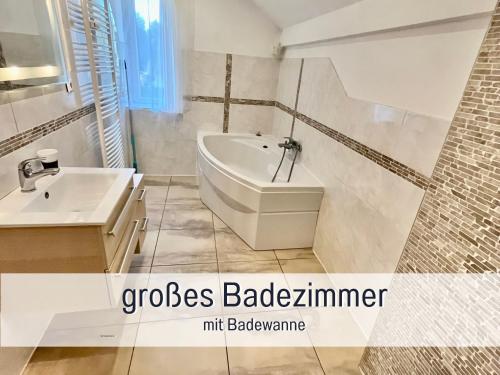 La salle de bains est pourvue d'une baignoire et d'un lavabo. dans l'établissement Möbliertes Haus in Nauen H1, à Nauen
