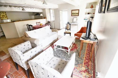 sala de estar con muebles blancos y TV en Maison de 2 chambres avec jardin clos a Grevilly en Grevilly