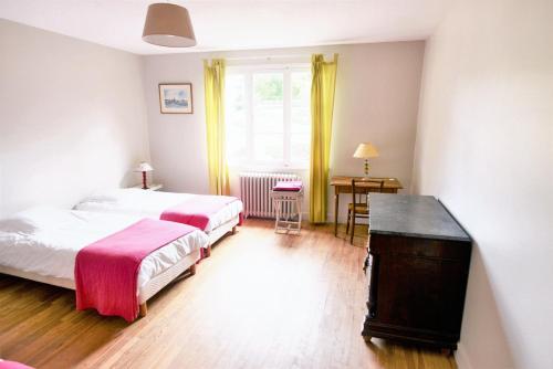 1 dormitorio con 2 camas, escritorio y ventana en Maison de 2 chambres avec jardin clos a Grevilly en Grevilly