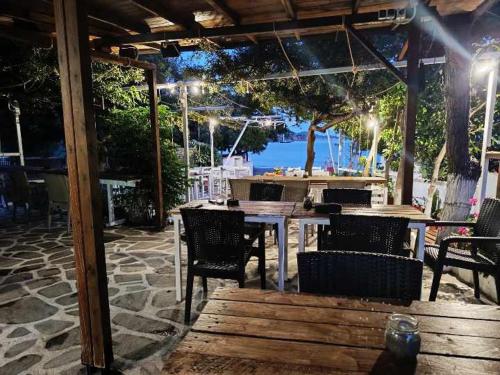 a patio with tables and chairs and a view of the water at Salty SeaShells Skiathos in Skiathos
