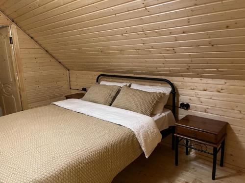 een bed in een kamer met een houten muur bij Rest House in Oni