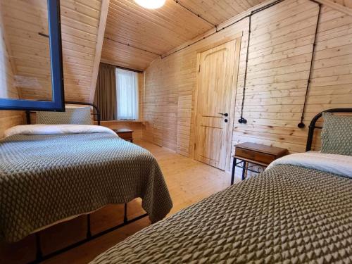 een slaapkamer met 2 bedden in een houten hut bij Rest House in Oni
