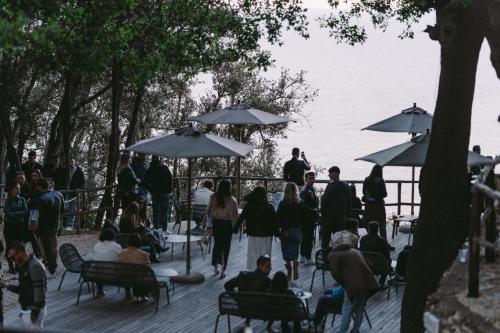 un gruppo di persone in piedi e seduti sotto gli ombrelloni di Casacon Sirolo a Sirolo