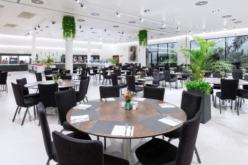 a dining room with tables and chairs and plants at Alexandre Fira Congress in Hospitalet de Llobregat