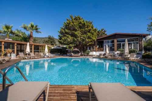 a pool at a hotel with chairs and umbrellas at Costa Bodrum City in Bodrum City