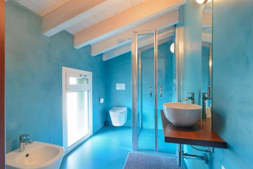 Baño azul con lavabo y aseo en Marilena en Castelnuovo del Garda