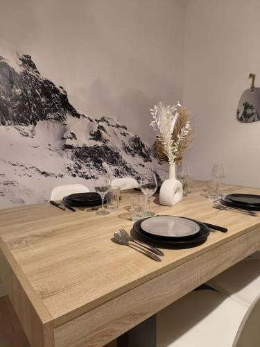 une table en bois avec des assiettes et des verres dans l'établissement Cocon de la vallée, à Munster