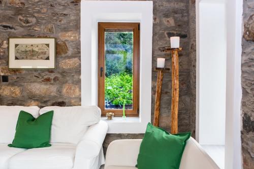 a living room with a white couch and green pillows at Traditional stone build country house Shale 