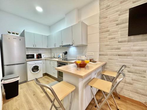 a kitchen with white cabinets and a table and chairs at CASITA NOCTILUCA in Santa Cruz de Tenerife