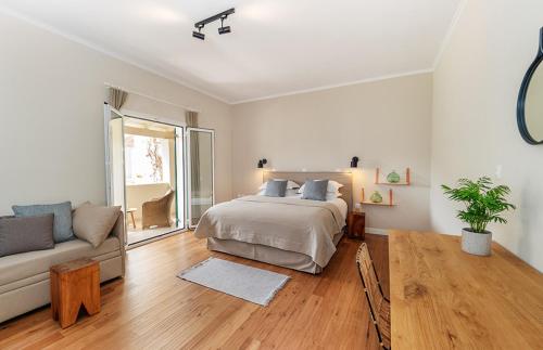 a white bedroom with a bed and a couch at Bella Mare Hotel in Kassiopi