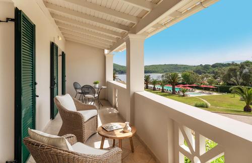 a balcony with chairs and a table and a view at Bella Mare Hotel in Kassiopi
