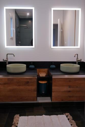 une salle de bain avec deux lavabos et deux miroirs dans l'établissement VILLAS BEAUMONT avec piscine et jacuzzi proche D'UZES ET ANDUZE, à Cannes-et-Clairan