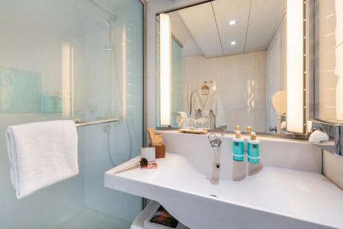 a bathroom with a sink and a mirror at Novotel Paris Est in Bagnolet